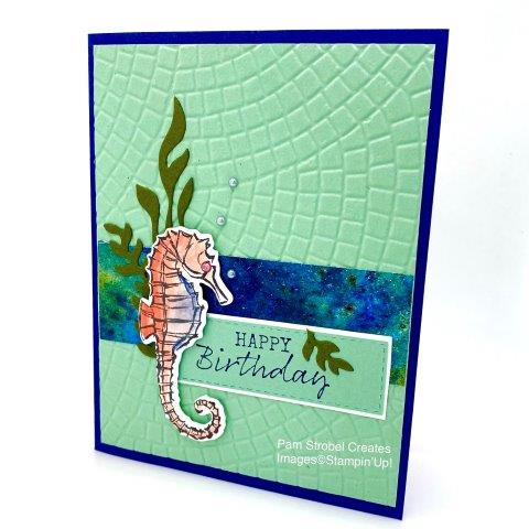 Fun colors and texture adorn this Seaside Notions stamp set using Night of Navy, Mint Macaron, Mossy Meadow and Calypso Coral colors. The Caylpso Coral works well with the other colors because it is considered a complimentary color. The seaweed look is created with the Smooth Sailing dies. Mosaic Embossing Folder creates the background. Enjoy more inspiration on my website : https://www.pamstrobelcreates.com/seaside-notions-stamp-set