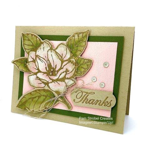 This gold embossed watercolored Magnolia Morning stamp set is on Crumb Cake card stock. It is watercolored with White Craft ink, allow to dry and add Blushing Bride ink to the base of each petal. the bold contrast of Mossy Meadow frames the image nicely as it flows over the edge of the border. Flower image cut using Magnolia Memory Dies. Enjoy more of this stamp set at my website : https://www.pamstrobelcreates.com/magnolia-morning-stamp-set